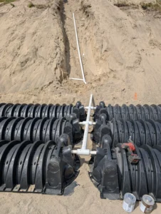 Close-up of PVC pressure distribution piping connections between infiltrator chambers on a sand mound system, highlighting precision plumbing work in the Okanagan.