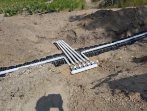 Installation of a Large Multi-Unit Type 2 septic system featuring a gravity dosing to pressure manifold assembly and distribution piping in the Okanagan.